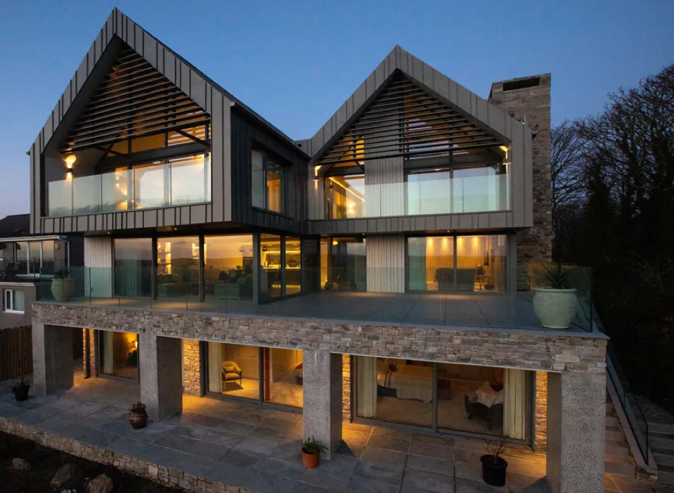 Completed ICF house with modern cladding, stone finishes and large glazed openings.